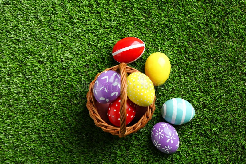 Wicker Basket with Painted Easter Eggs on Green Grass, Stock Photo