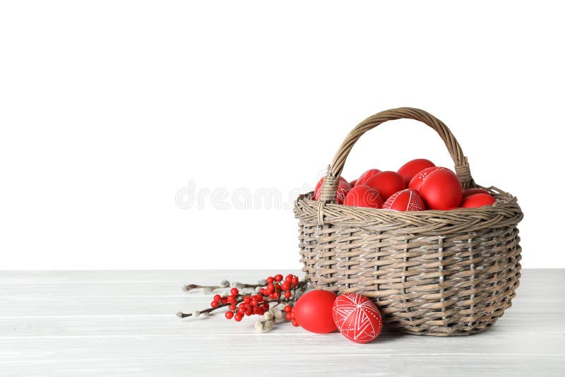 Wicker basket with painted red Easter eggs on table against white background royalty free stock photography Wicker basket with painted red Easter eggs on table against white background royalty free stock photography