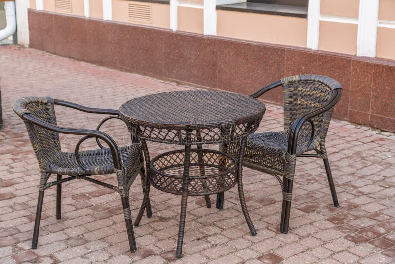 . Wicker table and chairs in empty cafe on the street in the city