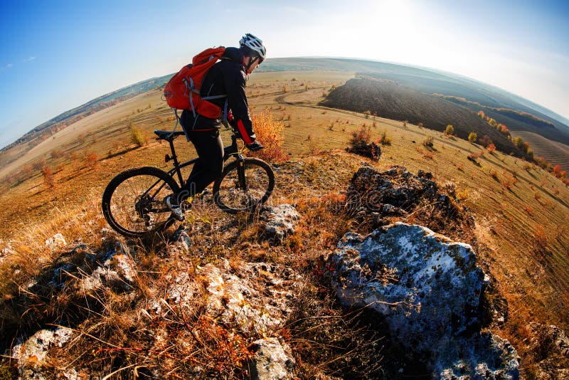 Wide angle view of a cyclist riding a bike on a nature trail in the mountains. stock photography Wide angle view of a cyclist riding a bike on a nature trail in the mountains. stock photography