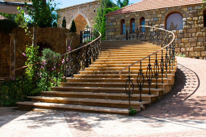 Wide curved stairs with ornate rail in a Lebanese village outdoors. Wide curved stairs with ornate rail in a Lebanese village outdoors