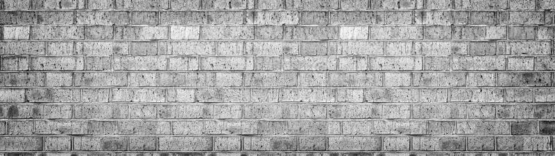 Wide gray brick wall texture. Rough light brickwork. Old cracked blocks panorama. Retro grunge widescreen background