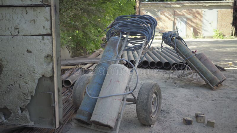 Wide shot of gas tanks and metal pipes in sunlight outdoors. Industrial materials on manufacturing site or factory