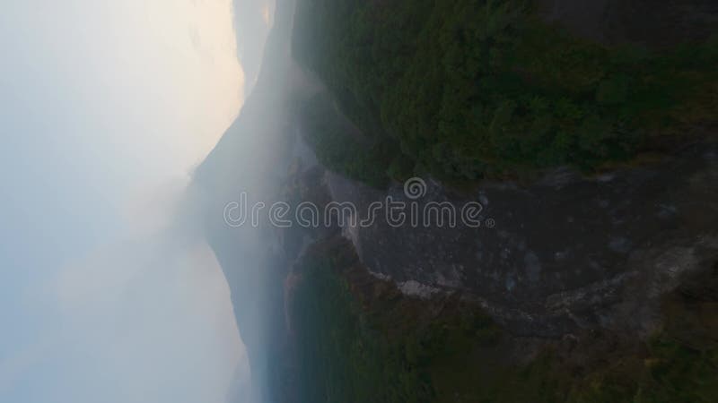 Wideo pionowe. widok z powietrza tropikalny ciemnoporanny kanion leśny zamrożony wulkan