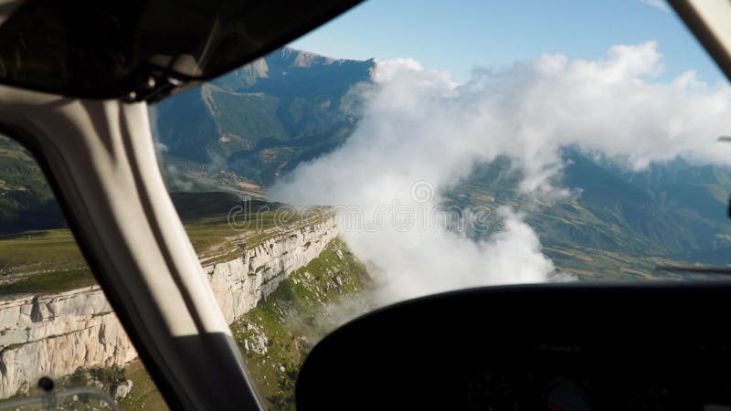 Widok kabiny latającego małego statku powietrznego. klif górski chmur w oknie samolotu