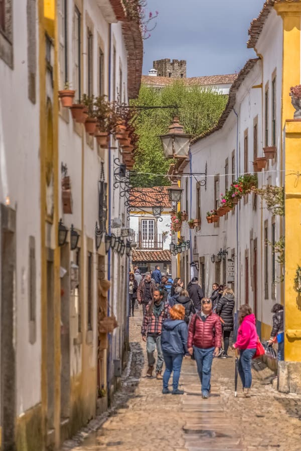 Widok portuguese ulica z budynkami i turystycznymi ludźmi na Portugalskiej średniowiecznej wiosce Ã, „bidos, w Portugalia obrazy stock Widok portuguese ulica z budynkami i turystycznymi ludźmi na Portugalskiej średniowiecznej wiosce Ã, „bidos, w Portugalia obrazy stock