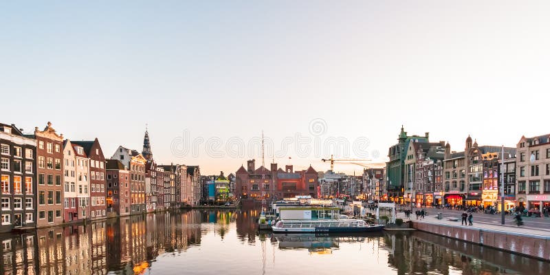 Widok przy sławnym Damrak podczas zmierzchu w Amsterdam Nether obraz stock Widok przy sławnym Damrak podczas zmierzchu w Amsterdam Nether obraz stock
