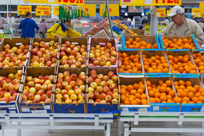 Moscow, Russia, may 2018: a view of a rows of cartons boxes with apples and oranges in supermarket editorial. Moscow, Russia, may 2018: a view of a rows of cartons boxes with apples and oranges in supermarket editorial
