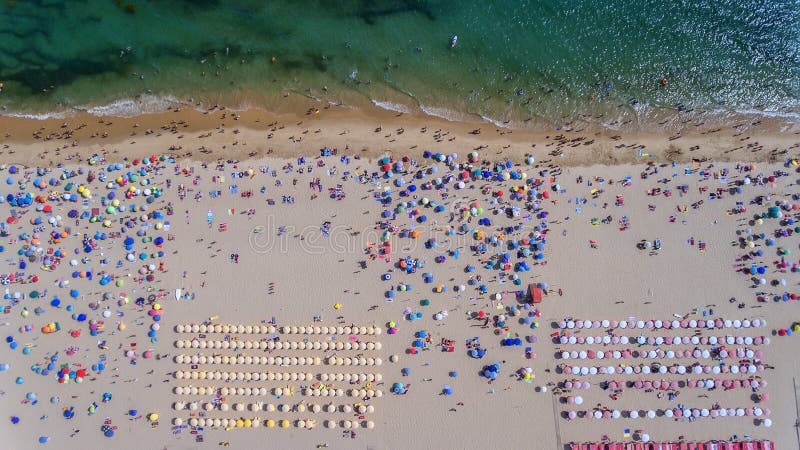 Widok z lotu ptaka piaskowata plaża z turystami pływa w pięknej wodzie morskiej obrazy stock Widok z lotu ptaka piaskowata plaża z turystami pływa w pięknej wodzie morskiej obrazy stock