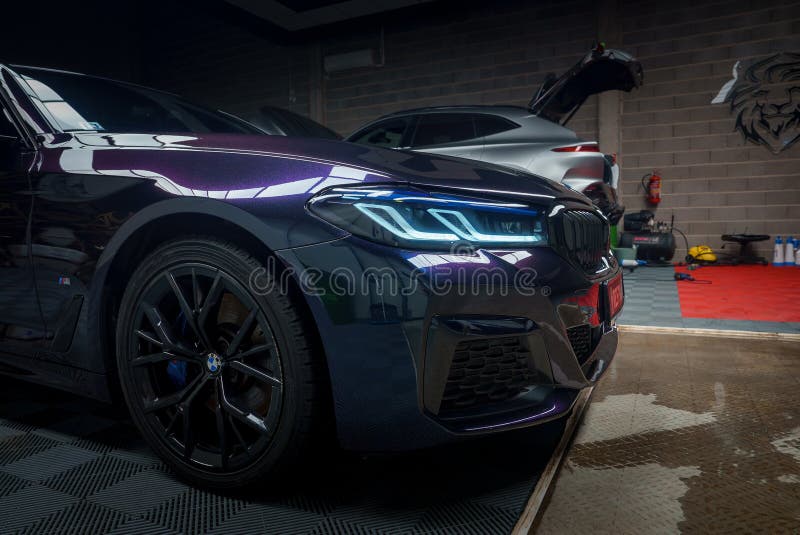 Widok zbliżeniowy elegancki samochód bmw w stroning garage niebieskie reflektory świecą jasno obrazy royalty free