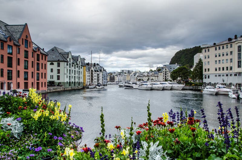 Widok łodzie i budynki w Alesund centrum miasta marina z colourful kwiatami w przedpolu fotografia royalty free Widok łodzie i budynki w Alesund centrum miasta marina z colourful kwiatami w przedpolu fotografia royalty free