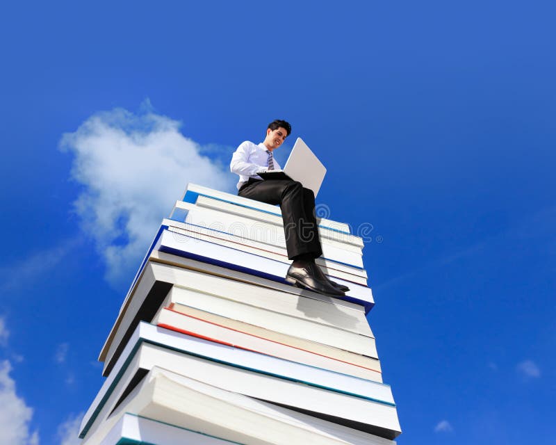 Knowledge is power - Happy business man using pc computer and sitting on a stack Of Books. Knowledge is power - Happy business man using pc computer and sitting on a stack Of Books