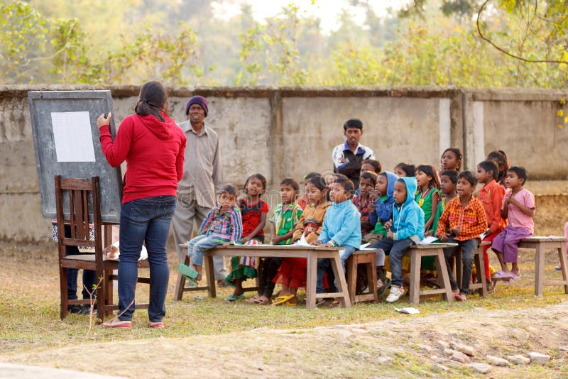 Teaching young Indian children in rural India outdoors with temporary classroom and boards. Child literacy program for poor village kids. Teaching young Indian children in rural India outdoors with temporary classroom and boards. Child literacy program for poor village kids.