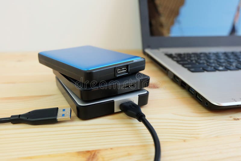 Wiele Kolorowi Przenośni zewnętrznie dyski twardzi USB3 (0) łączy laptop na drewnianym obraz royalty free Wiele Kolorowi Przenośni zewnętrznie dyski twardzi USB3 (0) łączy laptop na drewnianym obraz royalty free