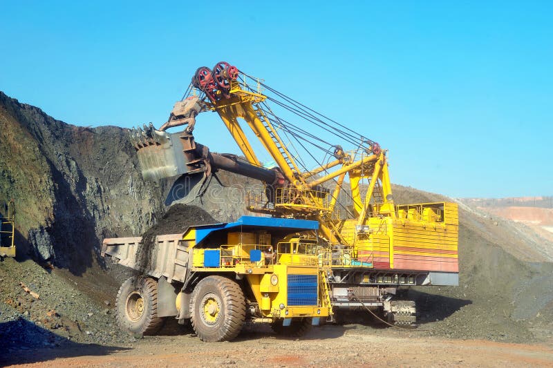Large quarry dump truck. Loading the rock in the dumper. Loading coal into body work truck. Mining truck mining machinery, to transport coal from open-pit. Large quarry dump truck. Loading the rock in the dumper. Loading coal into body work truck. Mining truck mining machinery, to transport coal from open-pit