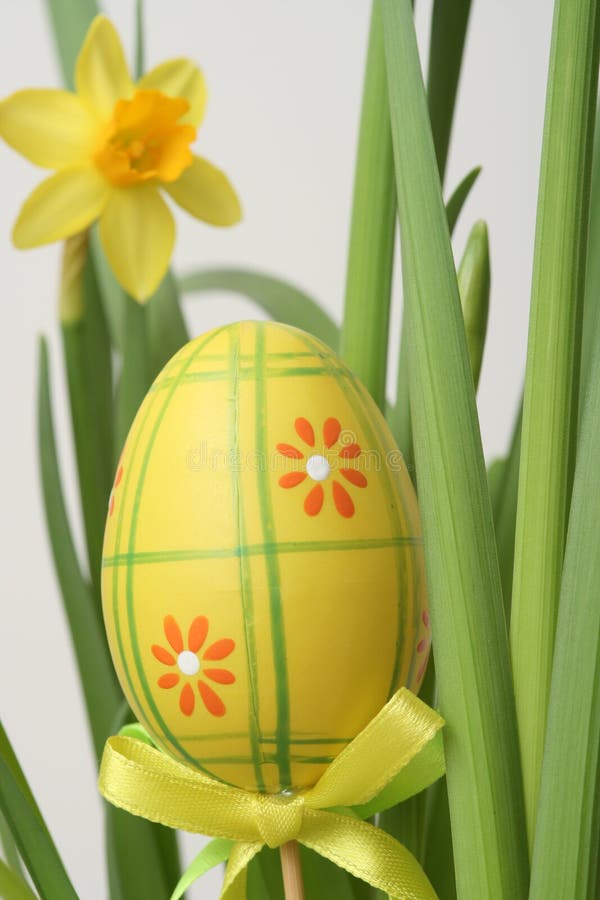 A deteiled close up a colored easter egg,nestled in the green grass with yellow flower. A deteiled close up a colored easter egg,nestled in the green grass with yellow flower.