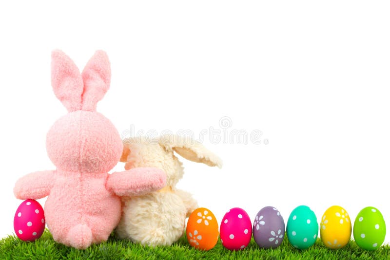 Hugging Easter bunnies on grass with colorful egg border over white, behind view. Hugging Easter bunnies on grass with colorful egg border over white, behind view