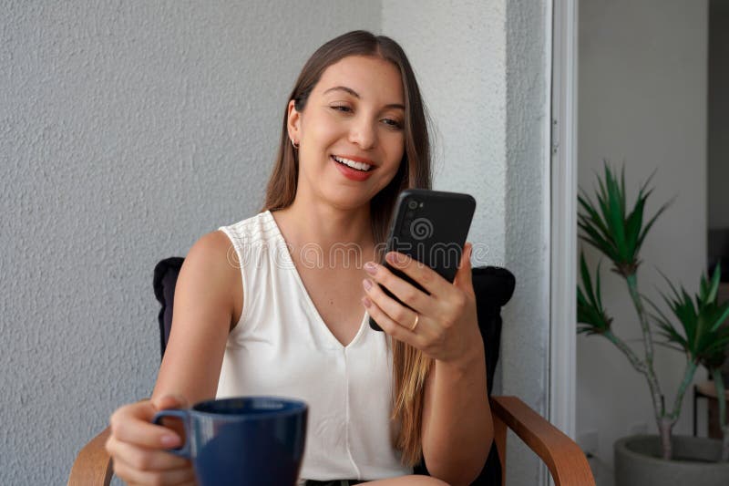 Wielonarodowa kobieta biznesowa używa smartfona do wideorozmów na balkonie mieszkania rano obrazy stock