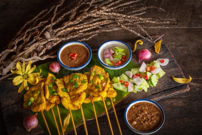 Wieprzowina satay z tajlandzkimi pikantno?? i arachidowym kumberlandem na bananowym li? ciu umieszczaj? cym na drewno stole fotografia stock