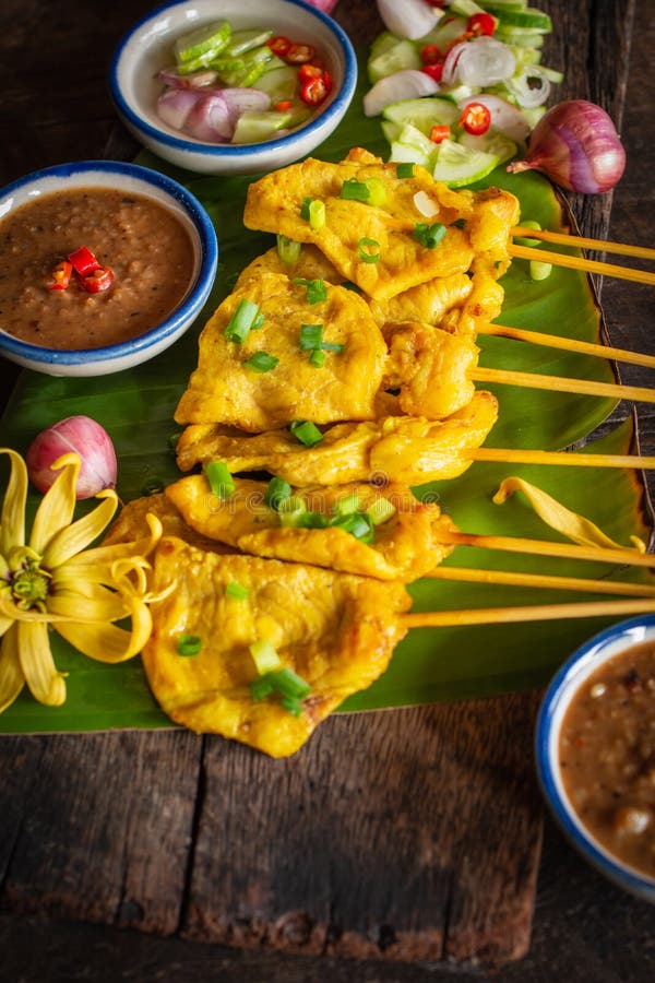 Wieprzowina satay z tajlandzkimi pikantno?? i arachidowym kumberlandem na bananowym li? ciu umieszczaj? cym na drewno stole obrazy stock