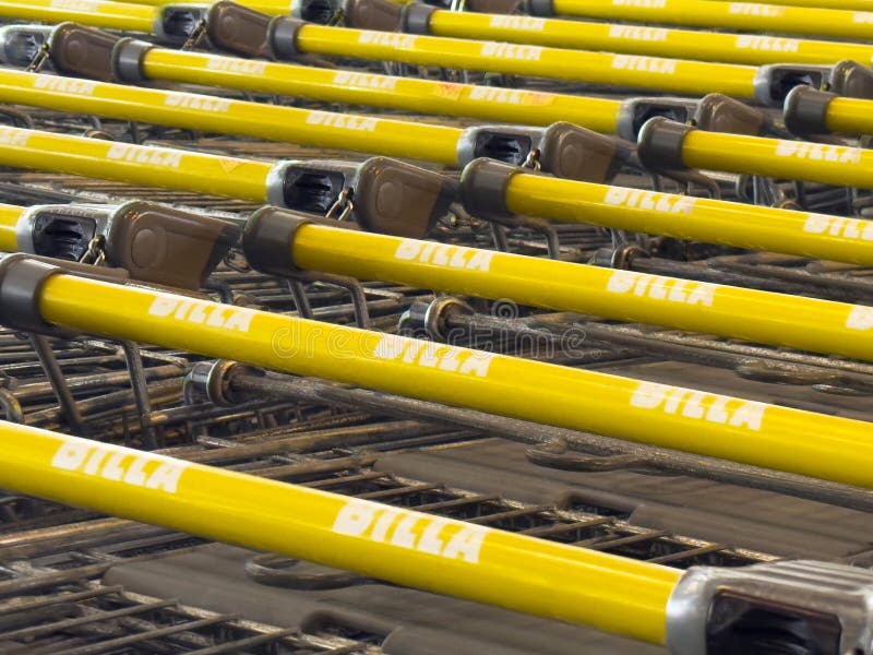 Wiersze żółtych wózków handlowych ułożone na parkingu supermarketów obrazy stock