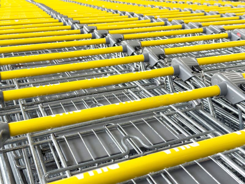 Wiersze żółtych wózków zakupowych ułożone starannie na parkingu detalicznym zdjęcie stock