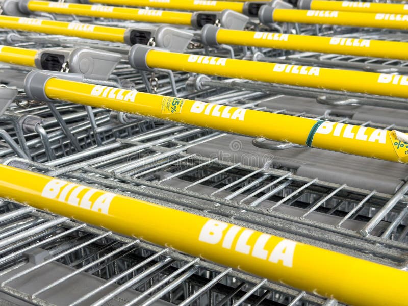 Wiersze żółtych wózków zakupowych z billa marka w parkingu sklepowym obrazy stock