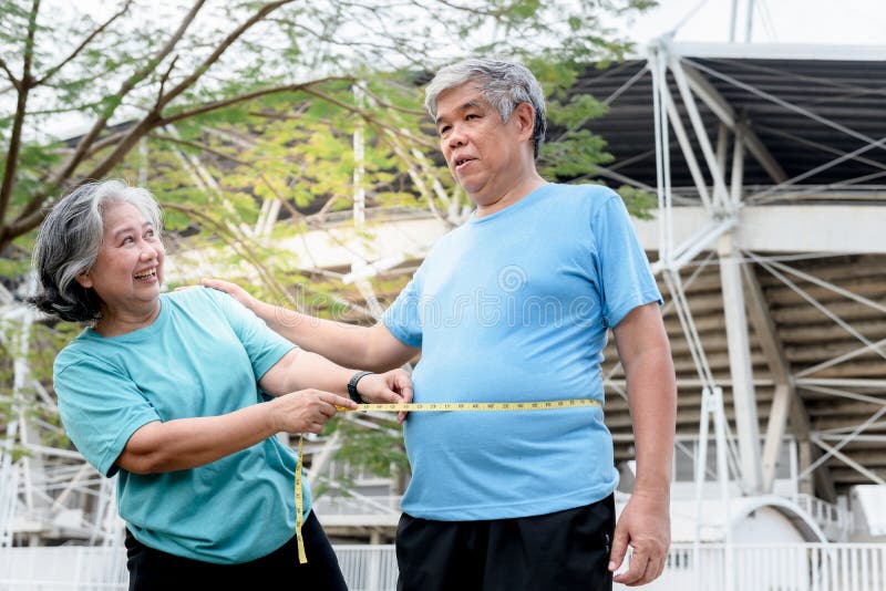 Asiático más viejo, esposa es un medidas su esposo y esposa cinturón cinta medidas, mientras ellos ellos eran ejercicio en.