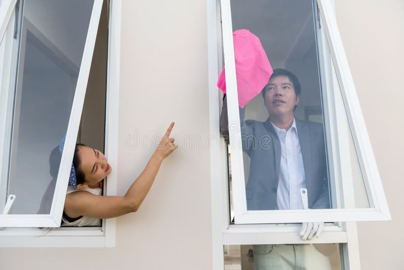 Wife order husband to clean house window stock photo Wife order husband to clean house window stock photo