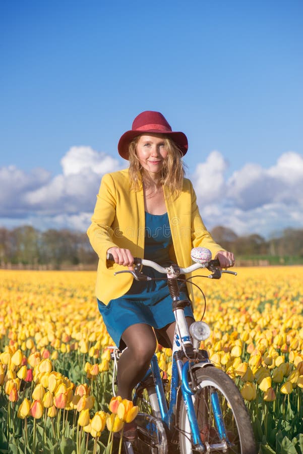 Wijfje bij zonnige tulpengebieden stock foto Wijfje bij zonnige tulpengebieden stock foto
