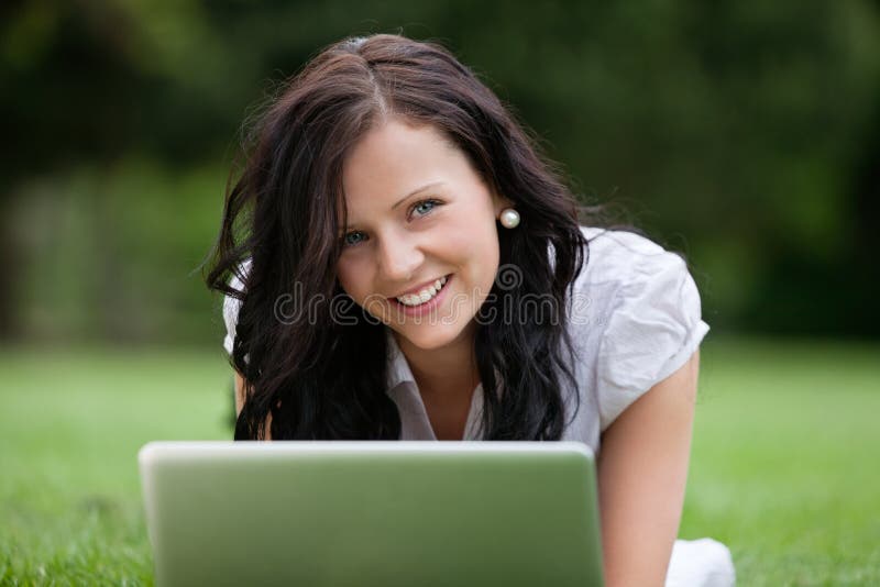 Wijfje die op Gras liggen die Laptop met behulp van stock foto's Wijfje die op Gras liggen die Laptop met behulp van stock foto's