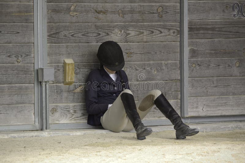 A female equestrian resting before a competition. A female equestrian resting before a competition