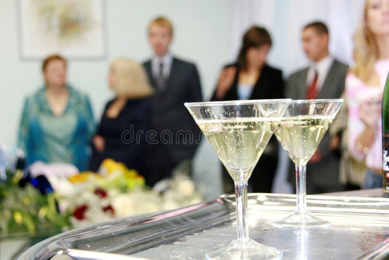 Visitors are ready to meet a newly-married couple and two wine glasses filled by a champagne wait for the speed up to be drunk and broken. Visitors are ready to meet a newly-married couple and two wine glasses filled by a champagne wait for the speed up to be drunk and broken