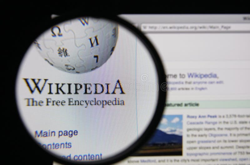 Photo of Wikipedia homepage on a monitor screen through a magnifying glass.