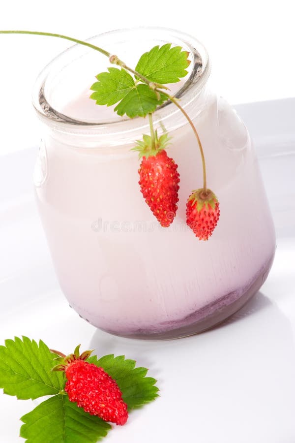 Closeup of open jar of organic yogurt and delicious wild strawberries over white background. Closeup of open jar of organic yogurt and delicious wild strawberries over white background