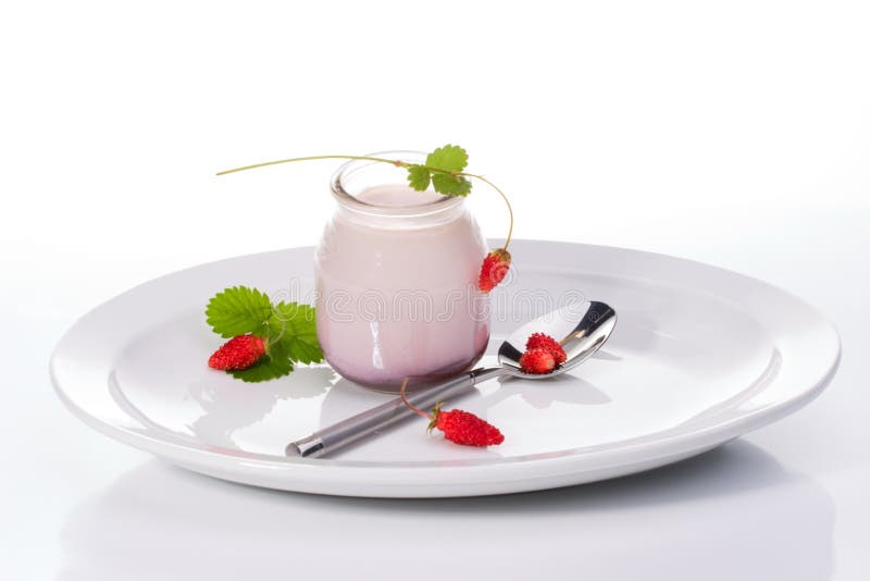 Jar of organic yogurt and delicious wild strawberries over white background. Jar of organic yogurt and delicious wild strawberries over white background