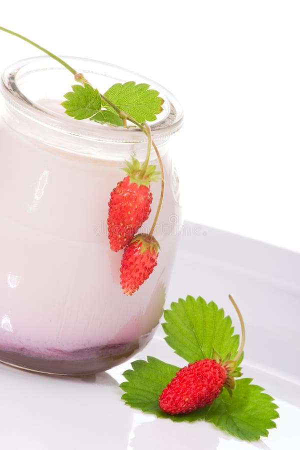Closeup of open jar of organic yogurt and delicious wild strawberries over white background. Closeup of open jar of organic yogurt and delicious wild strawberries over white background