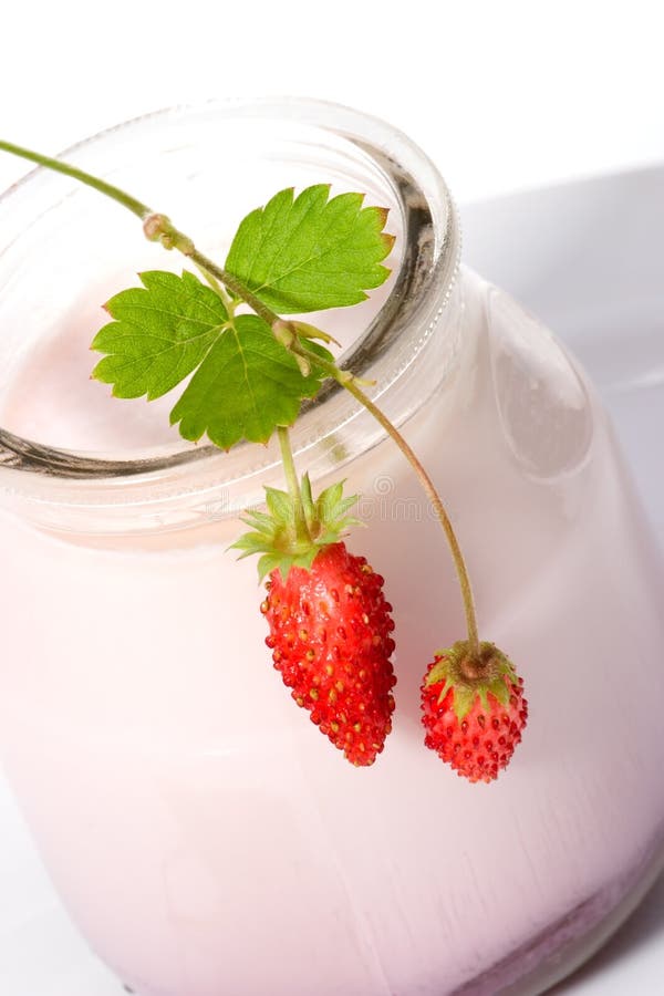 Closeup of open jar of organic yogurt and delicious wild strawberries. Closeup of open jar of organic yogurt and delicious wild strawberries