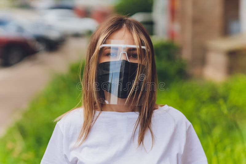 Portrait happy woman wile wearing a face shield for protection from cold and flu and viruses. Young woman with face mask in the street. Woman wearing face mask because of air pollution in the city. Portrait happy woman wile wearing a face shield for protection from cold and flu and viruses. Young woman with face mask in the street. Woman wearing face mask because of air pollution in the city