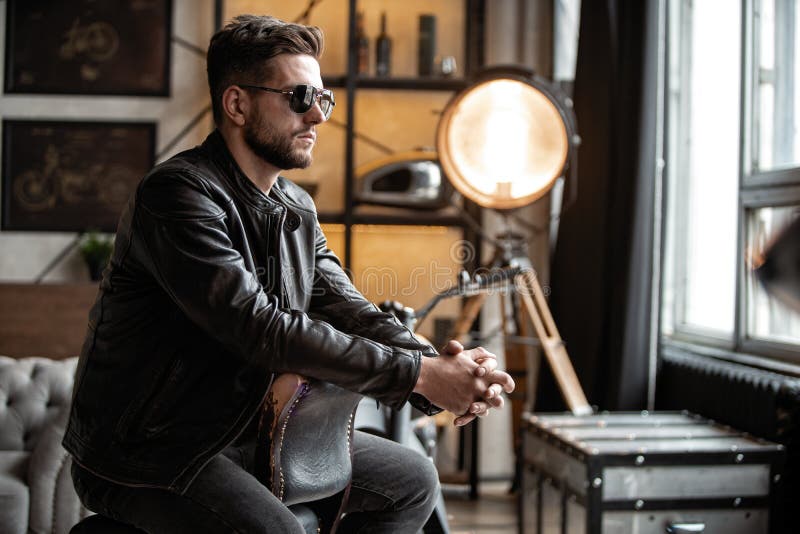 Handsome Young Man in Leather Jacket Looking Away while Sitting on the ...