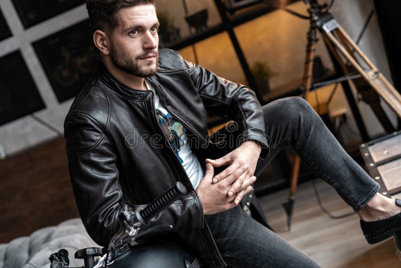 Handsome Young Man in Leather Jacket Looking Away while Sitting on the ...