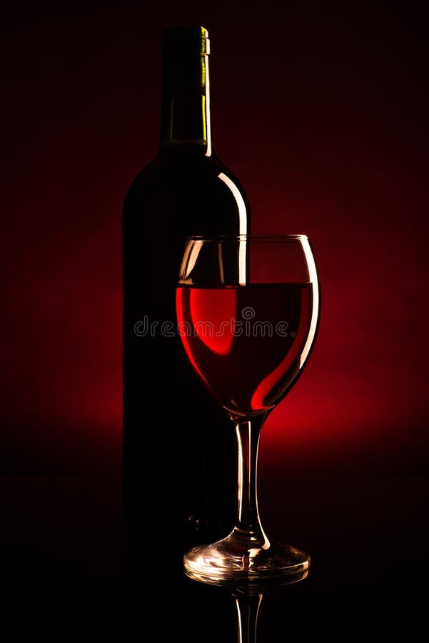 Silhouette of bottle and glass of red wine over dark red background. Silhouette of bottle and glass of red wine over dark red background.