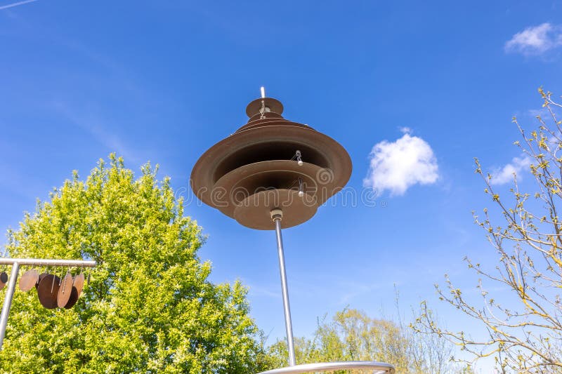 Wind Chimes in the Park Against the Blue Sky with White Clouds Stock