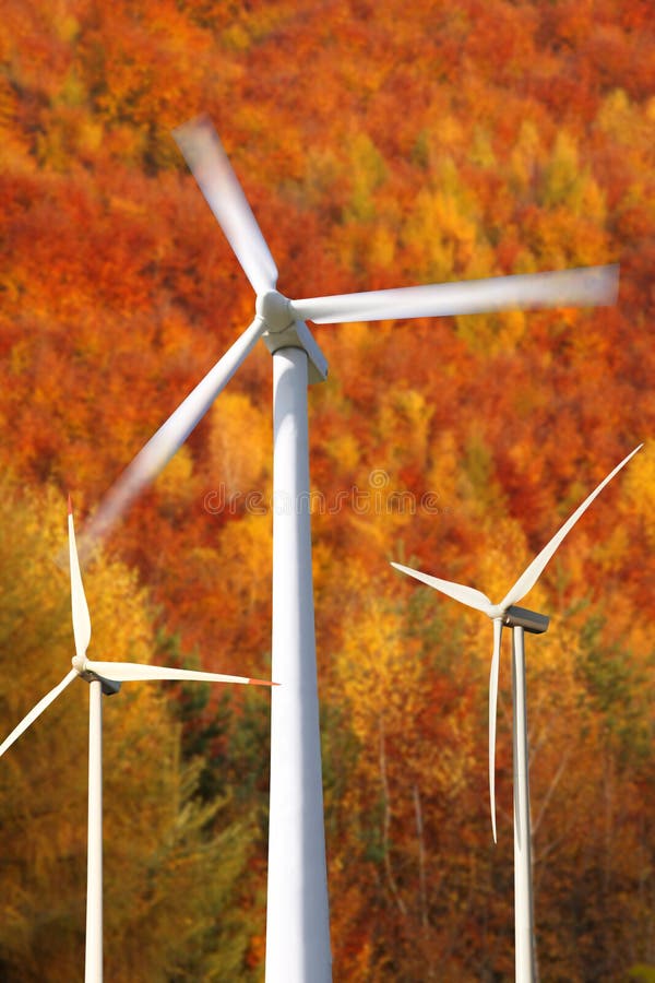 Wind Mills Power Generators Against Forest Stock Image 