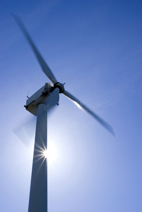 Spinning wind turbine with sun behind it. Spinning wind turbine with sun behind it