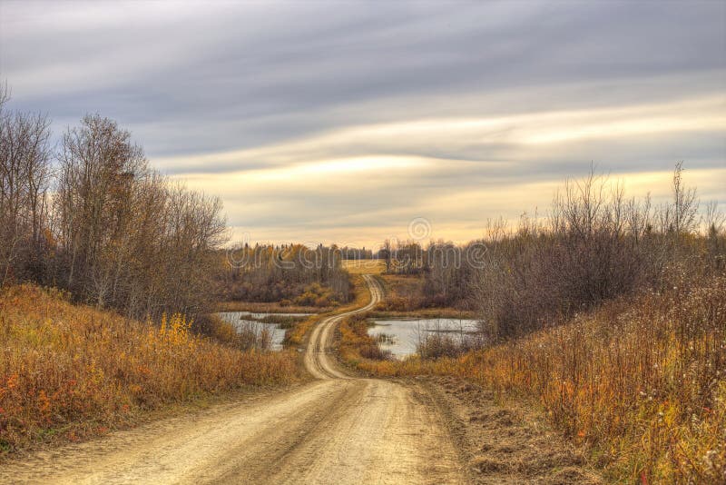 Winding dirt road through autumn valley