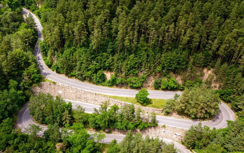 Winding road through the forest, from high mountain pass, in summer time