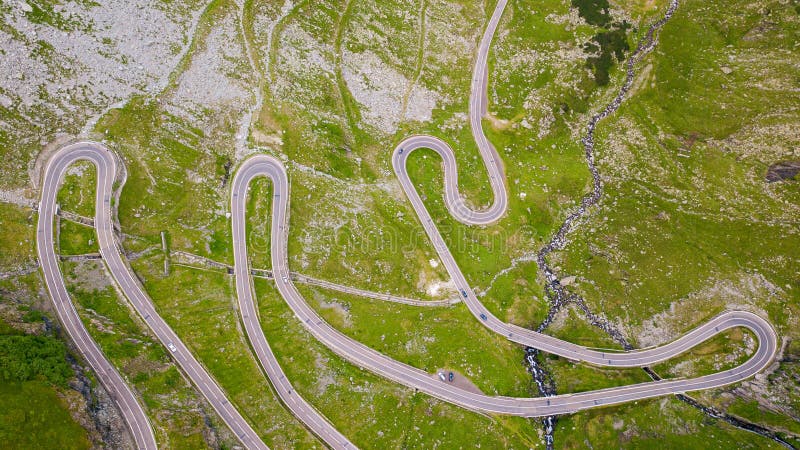 Winding road through the forest, from high mountain pass, in summer time