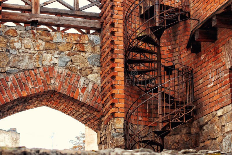 A winding spiral staircase used as fire escape in old gothic brick wall building