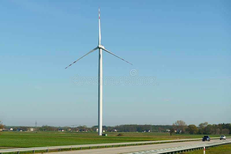 Windkraftanlage eines Windkraftwerks, das sich auf der Straße vor dem Hintergrund eines blauen Himmels befindet. stockbilder
